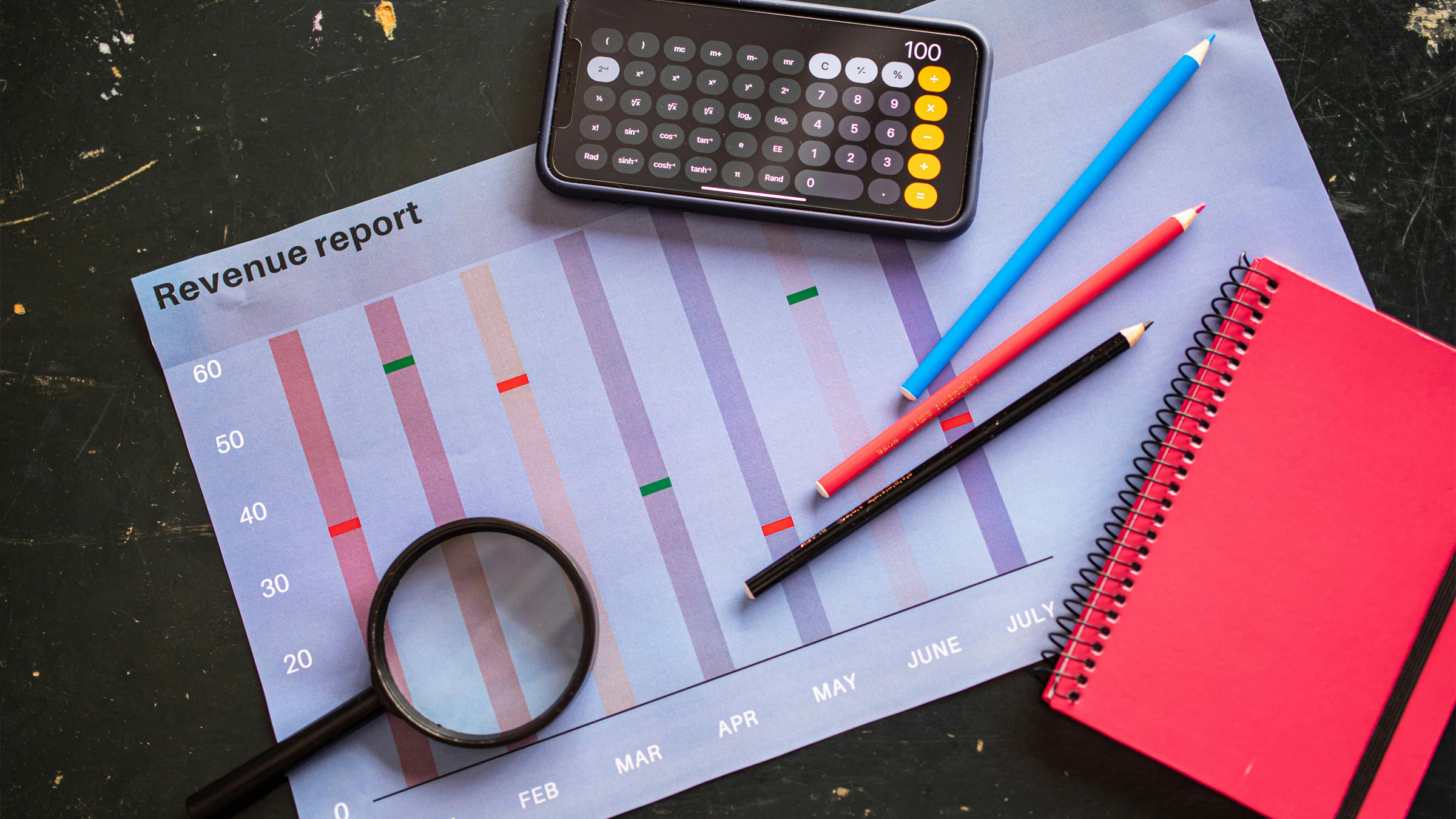 An accountant's desk covered in spreadsheets and a coffee cup at midnight