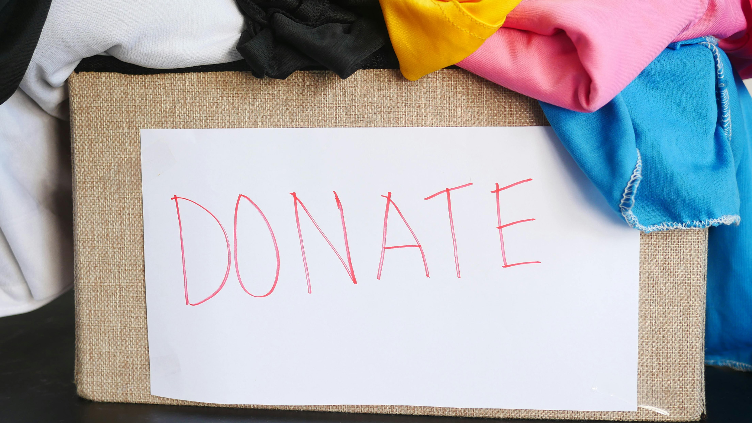 A volunteer sorting donated goods on a warehouse table